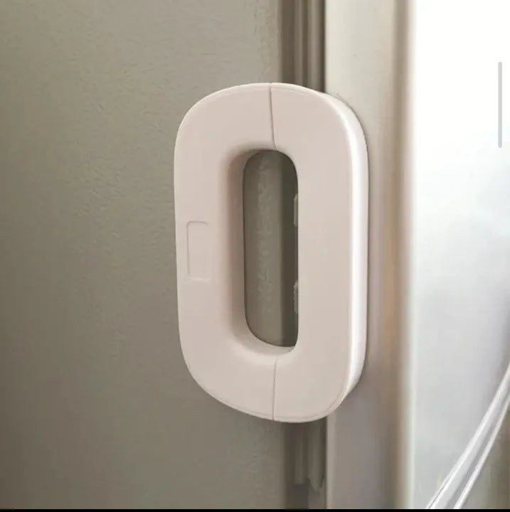 White adhesive refrigerator safety lock shown secured on fridge door